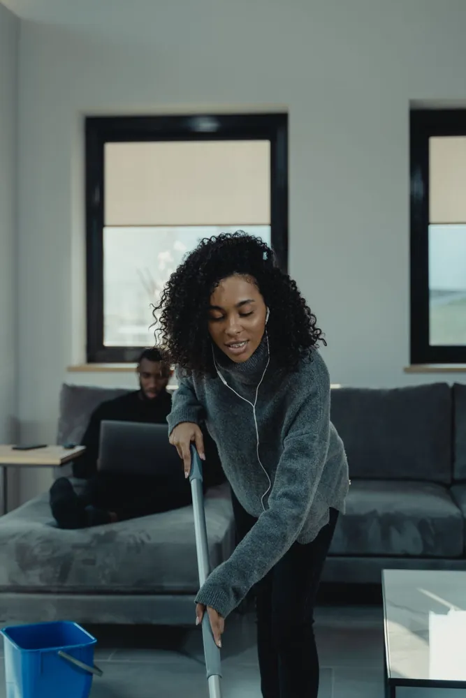 A cleaner mopping a living room